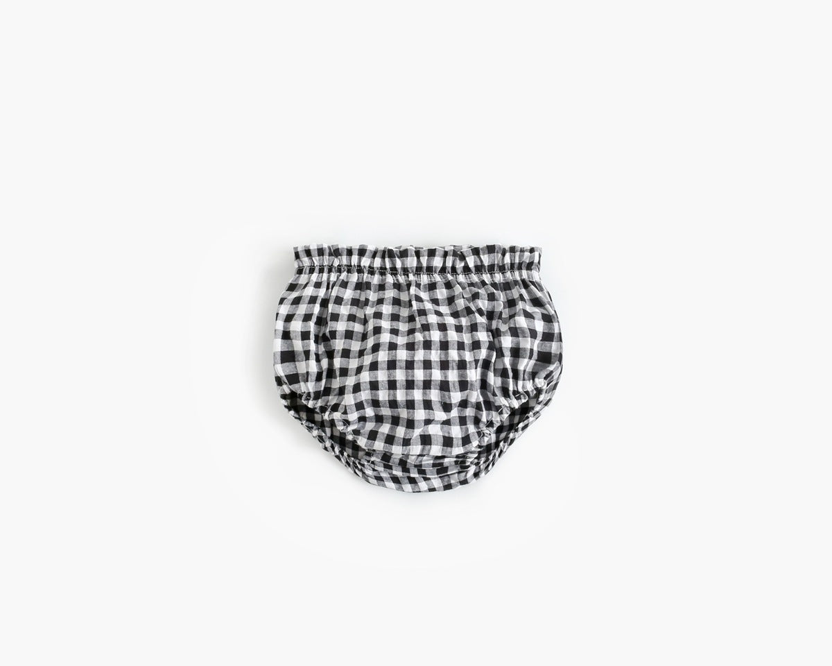 Black and white checkered baby bloomers on a light gray background