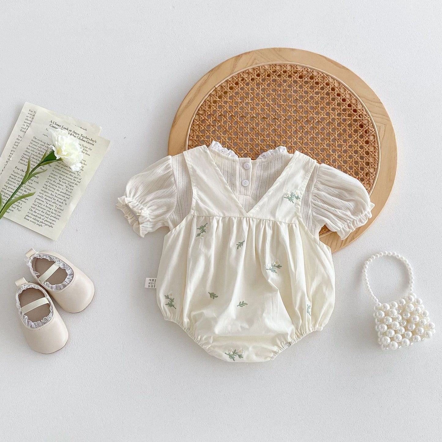 Baby romper with matching shoes on a light gray background