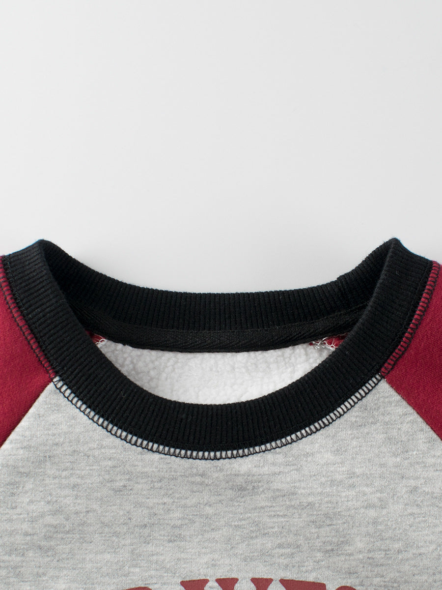 Close-up of a sweater collar with black trim on a gray and red garment.