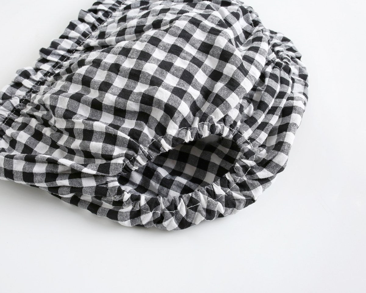 Black and white checkered shower cap on a light gray background