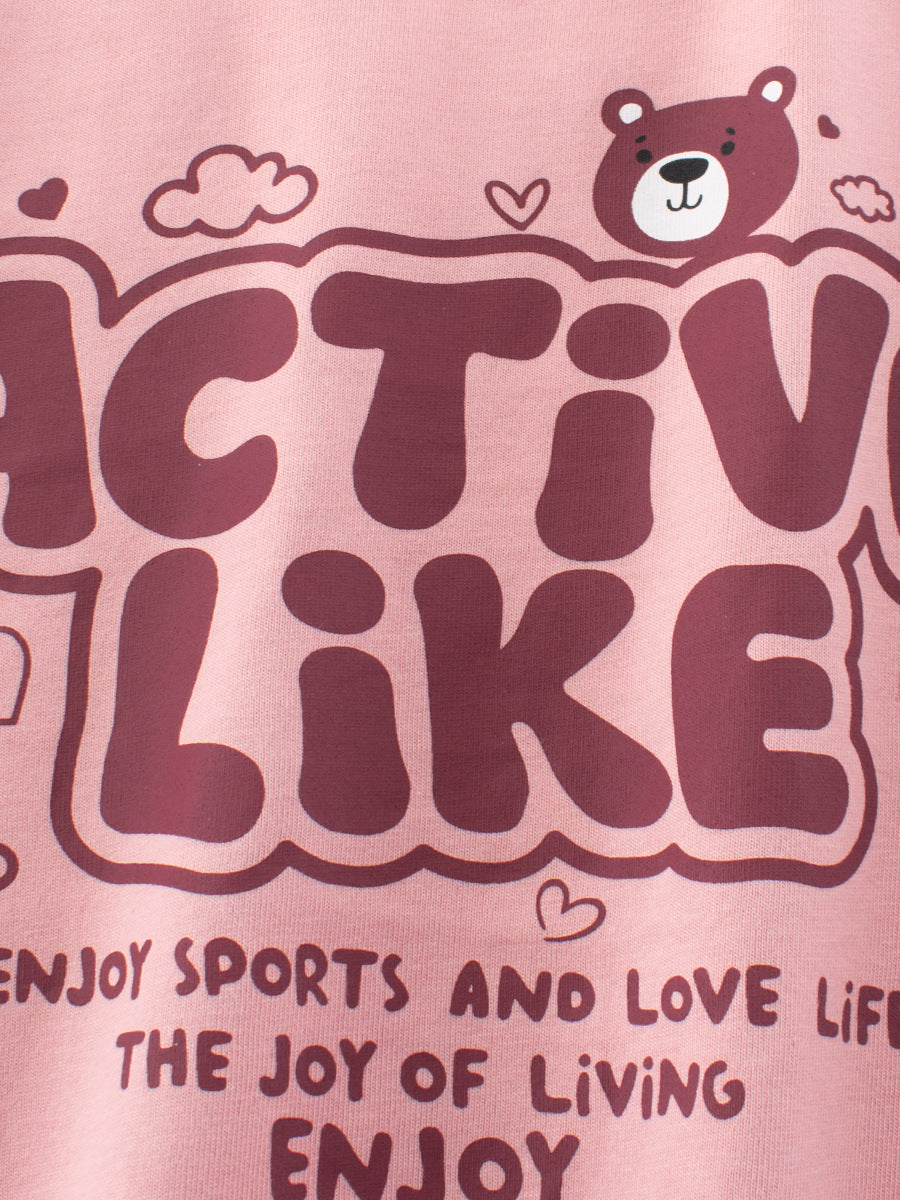 Pink t-shirt with bear graphic and text on a pink background