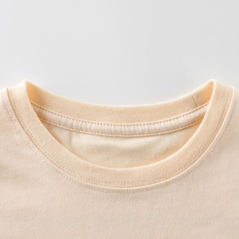 Close-up of a beige t-shirt collar on a light gray background