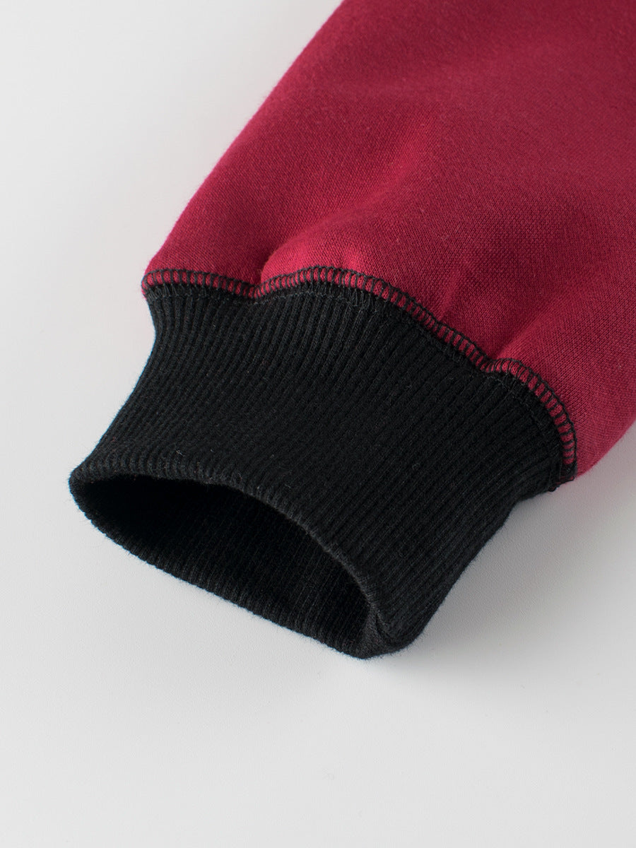 Close-up of a red fabric with black ribbed trim on a white background