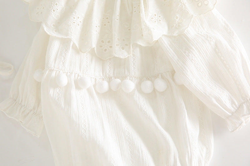 Close-up of a white lace garment with intricate detailing on a light background