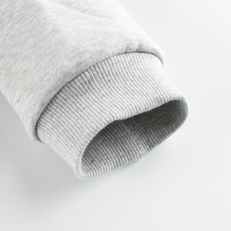 Close-up of a gray sweater sleeve on a light gray background