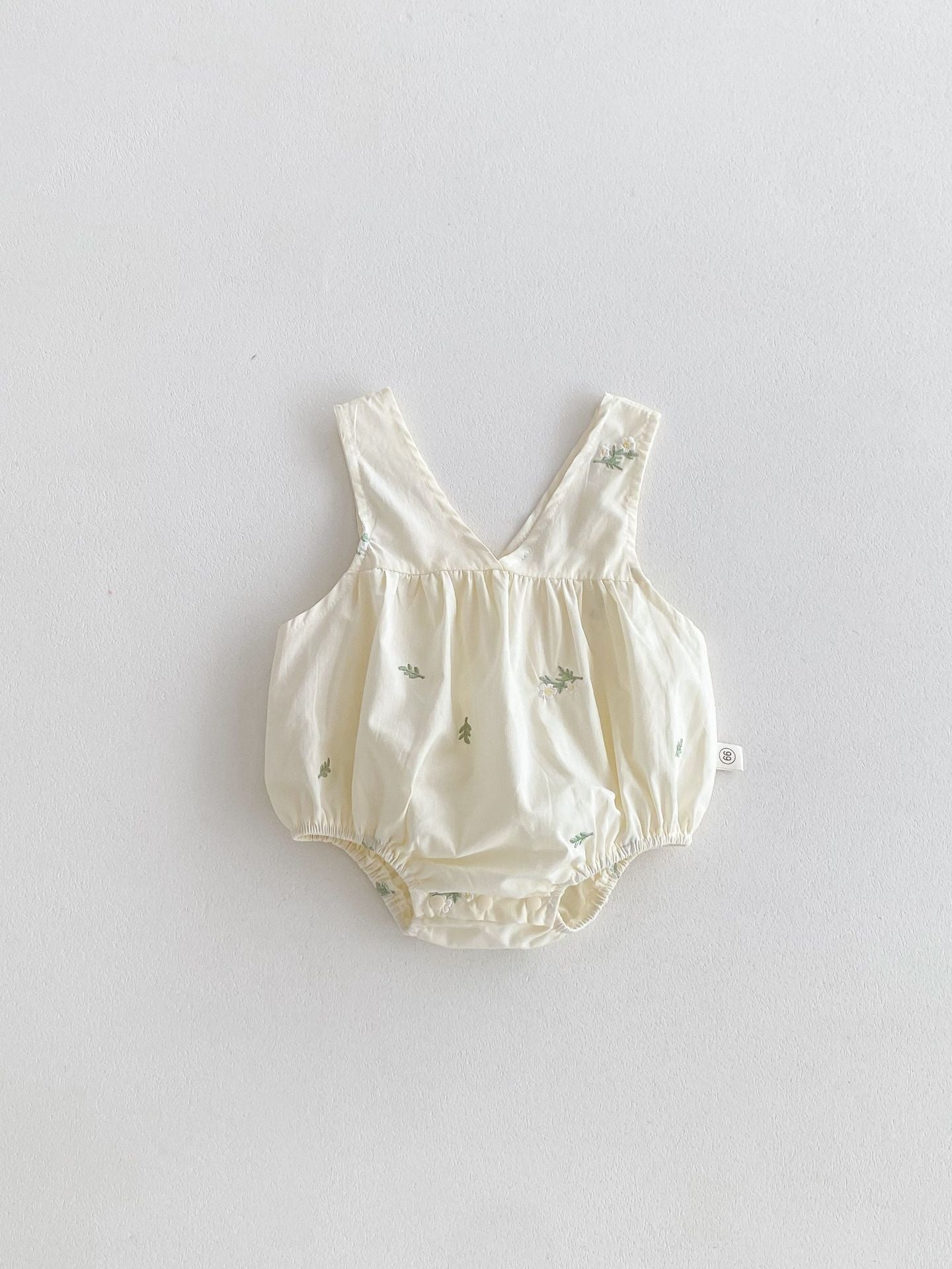 Baby romper with floral pattern on a light gray background
