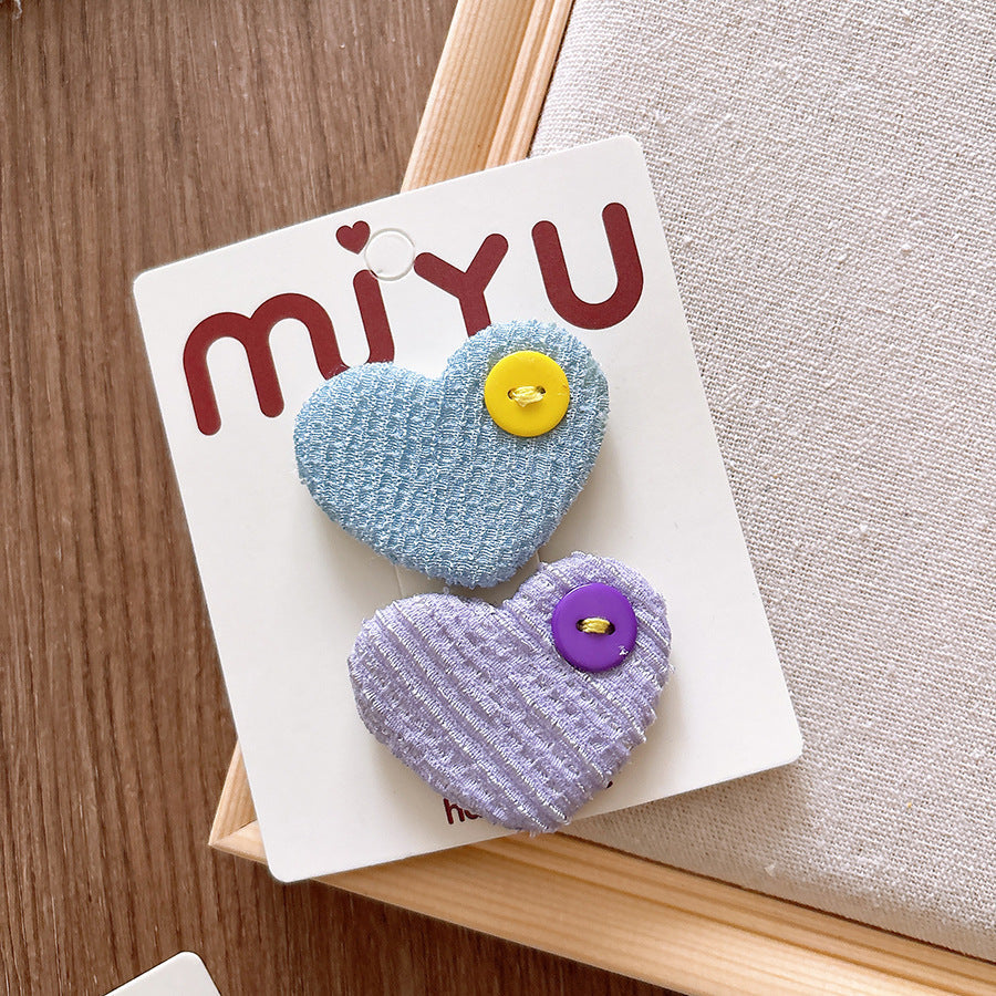 Heart-shaped fabric pins with buttons on a Miyu branded card.