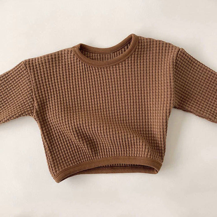 Brown textured sweater on a light beige background