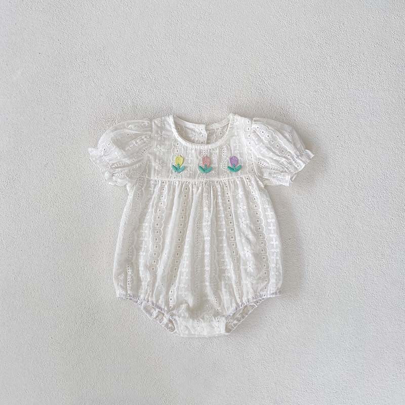 White baby romper with floral embroidery on a light gray background