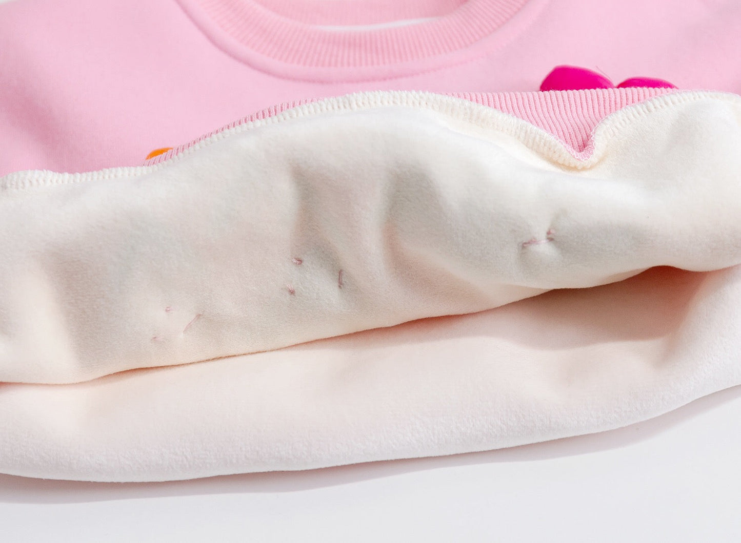 Close-up of a pink garment with visible stains on a white background