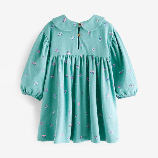 Green dress with butterfly pattern on a white background