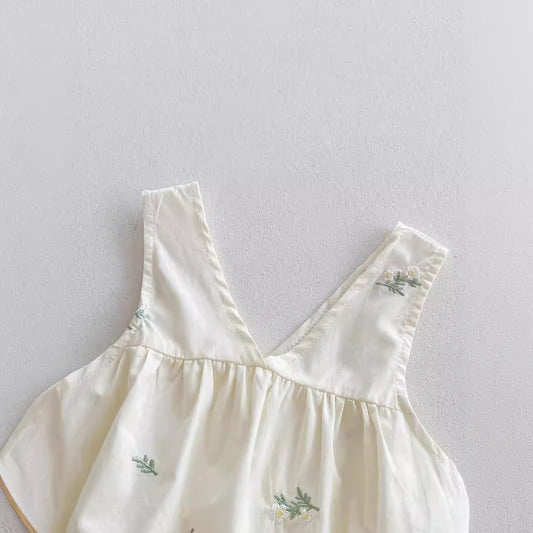 White dress with floral embroidery on a light gray background