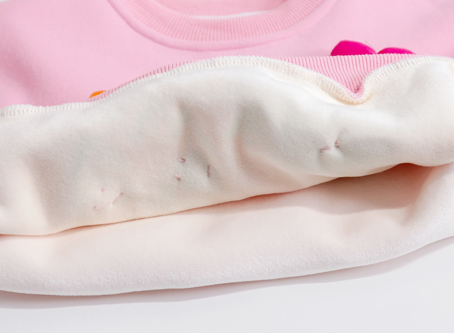 Close-up of a pink garment with visible stains on a white background